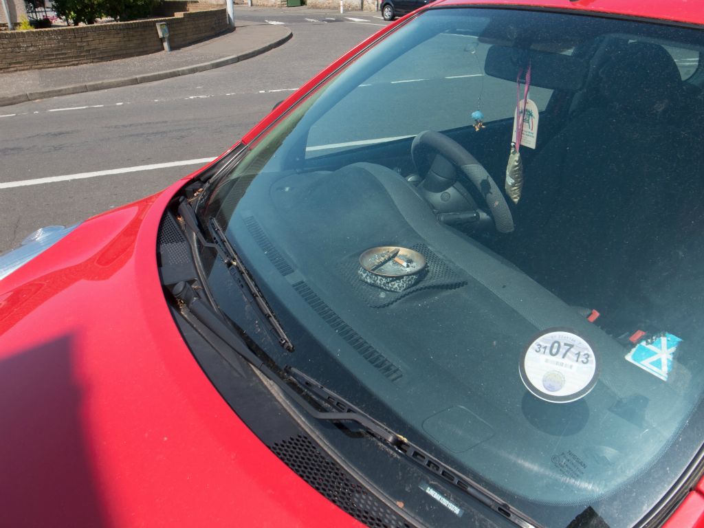 A partially filled ashtray in a red car.