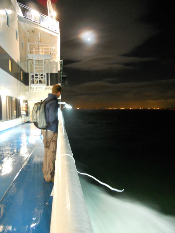 The lights of Calais come into view under a full moon on the ferry from Doer to Calais.